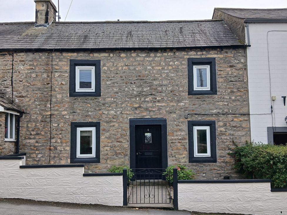 A house with stone walls and a black door at 4 Oak Cottages in Bentham, Yorkshire
