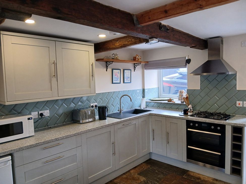 A kitchen with cabinets and appliances at 4 Oak Cottages in Bentham, Yorkshire