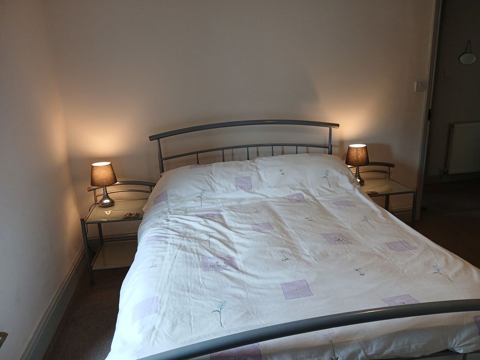 A bed with bedside tables and lamps at 4 Oak Cottages in Bentham, Yorkshire