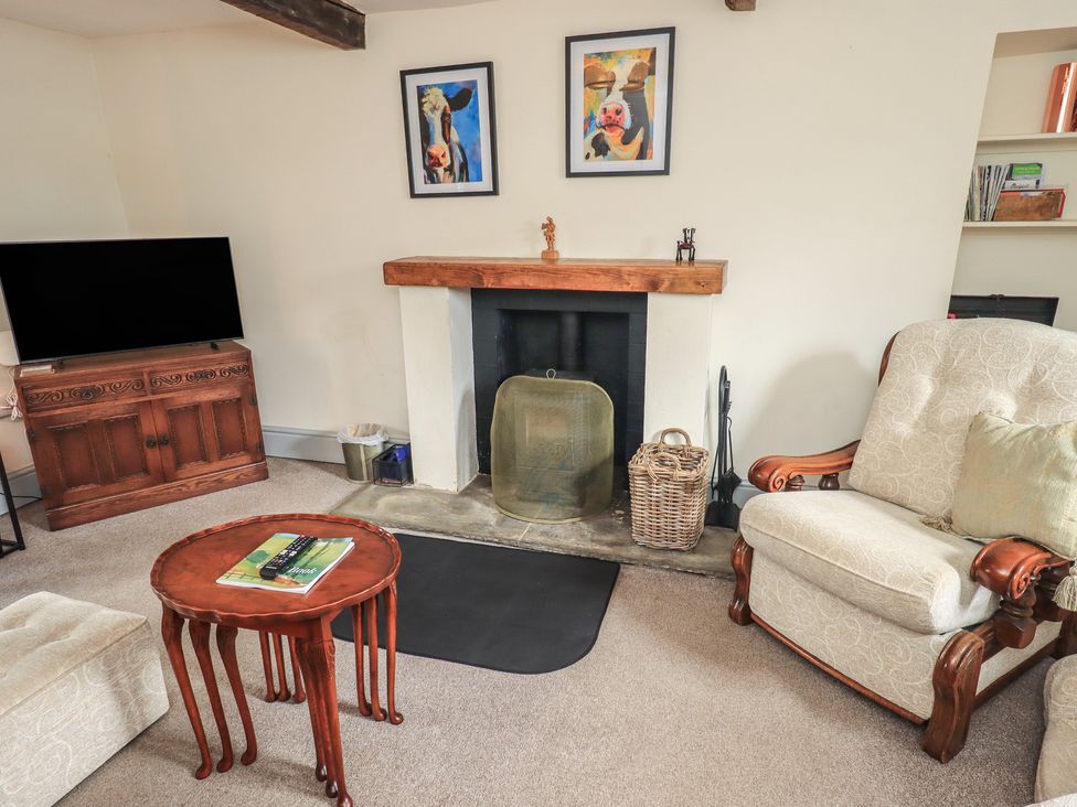 A living room with a fireplace and TV at 4 Oak Cottages in Bentham, Yorkshire
