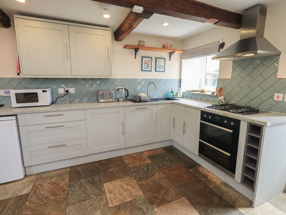 A kitchen with cabinets and a stove at 4 Oak Cottages in Bentham, Yorkshire