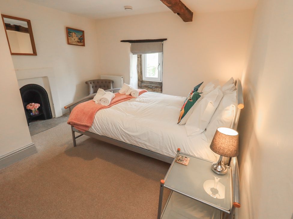 A bedroom with a bed and a lamp at 4 Oak Cottages in Bentham, Yorkshire