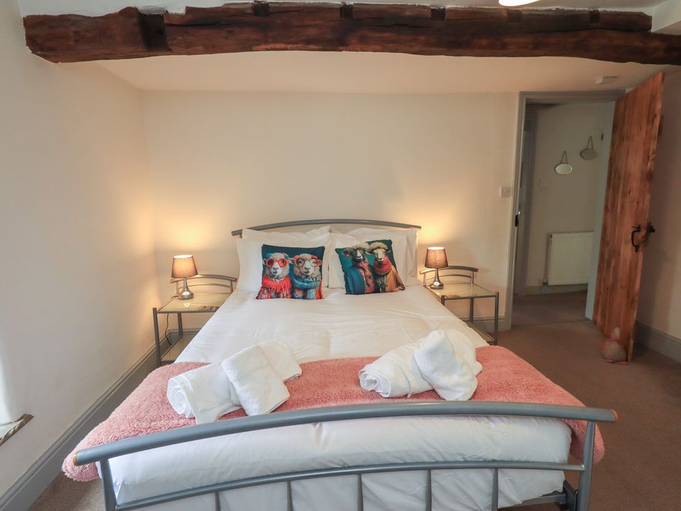 A bedroom with a bed and bedside tables at 4 Oak Cottages in Bentham, Yorkshire