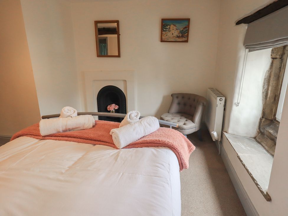 A bedroom with a bed and chair at 4 Oak Cottages in Bentham, Yorkshire