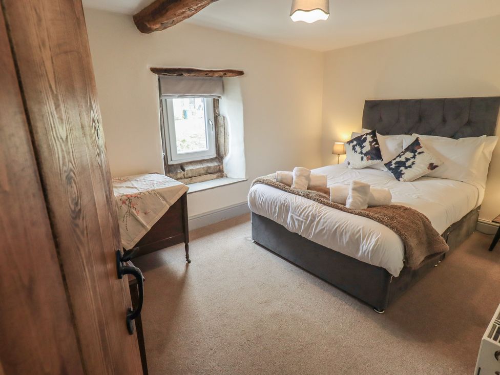 A bedroom with a bed and a window at 4 Oak Cottages in Bentham, Yorkshire