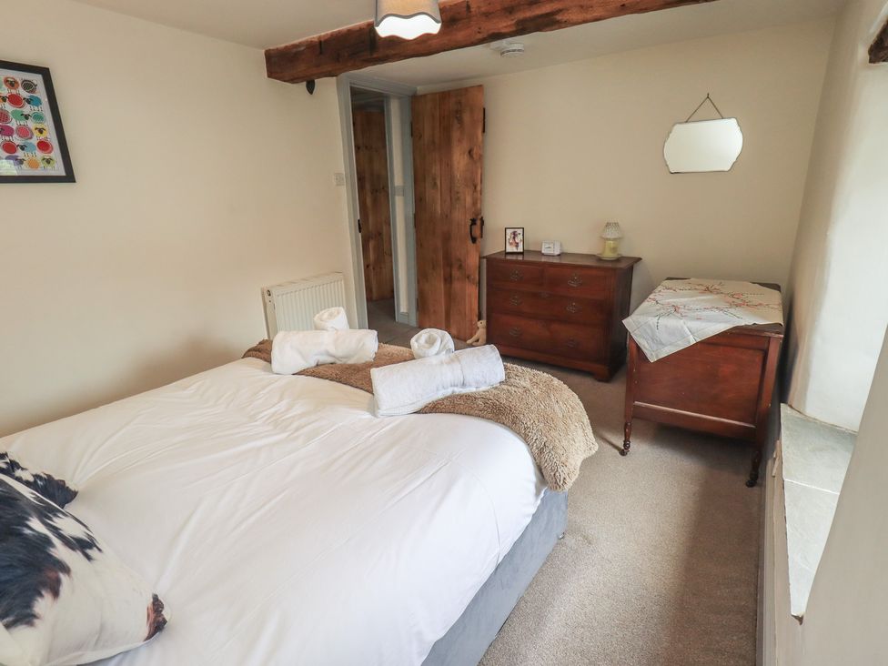 A bedroom with a bed and dresser at 4 Oak Cottages in Bentham, Yorkshire