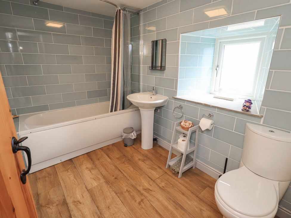A bathroom with a bath tub, wash basin and toilet at 4 Oak Cottages in Bentham, Yorkshire