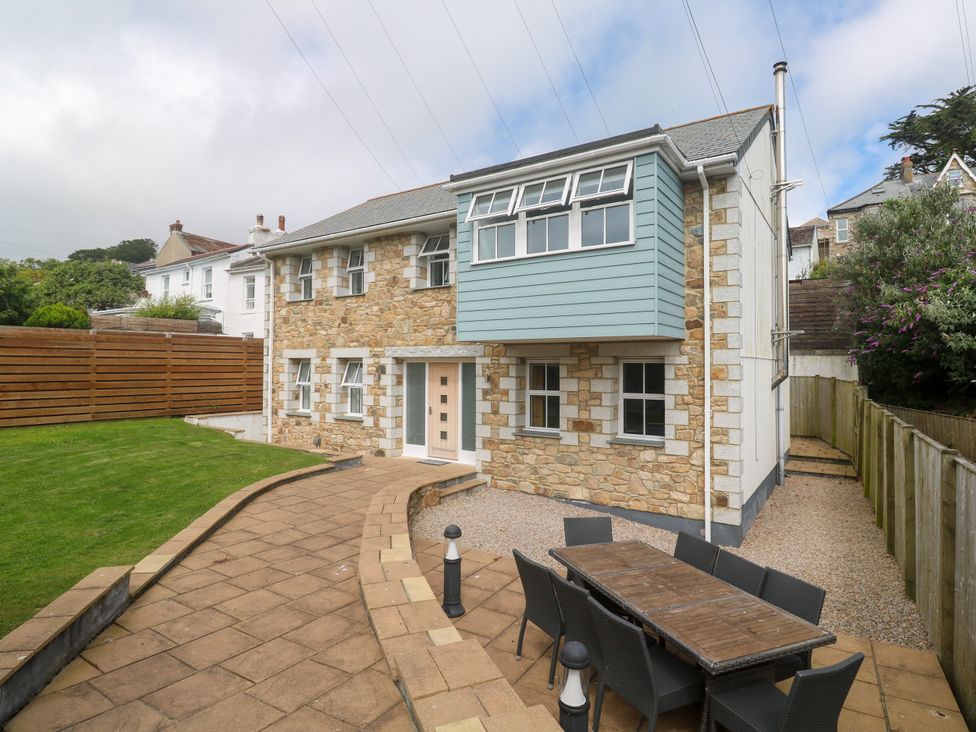 A house with a garden and patio furniture at Rosevale Villa in St Ives
