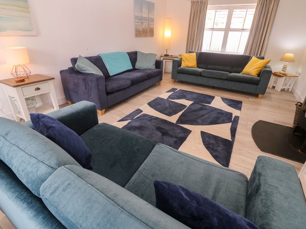 A living room with sofas and a rug at Rosevale Villa in St Ives
