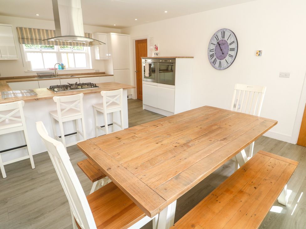A kitchen with a dining table and stove at Rosevale Villa in St Ives
