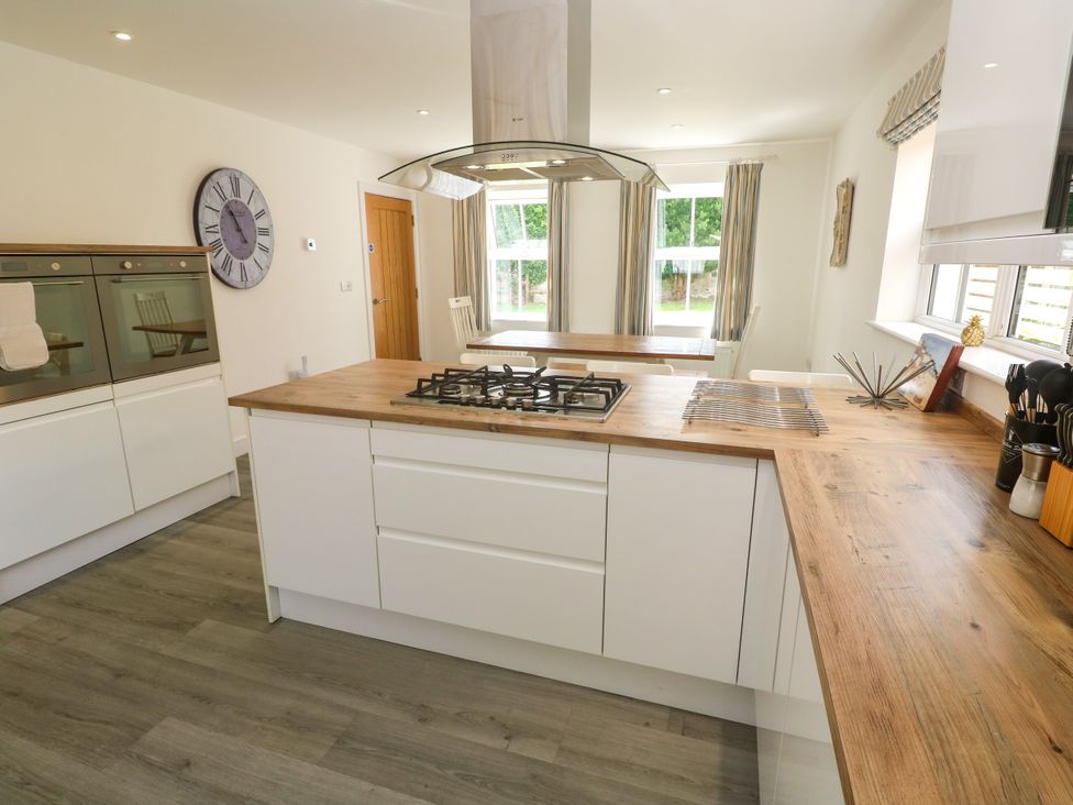 A kitchen with a gas cooker and dining table at Rosevale Villa in St Ives