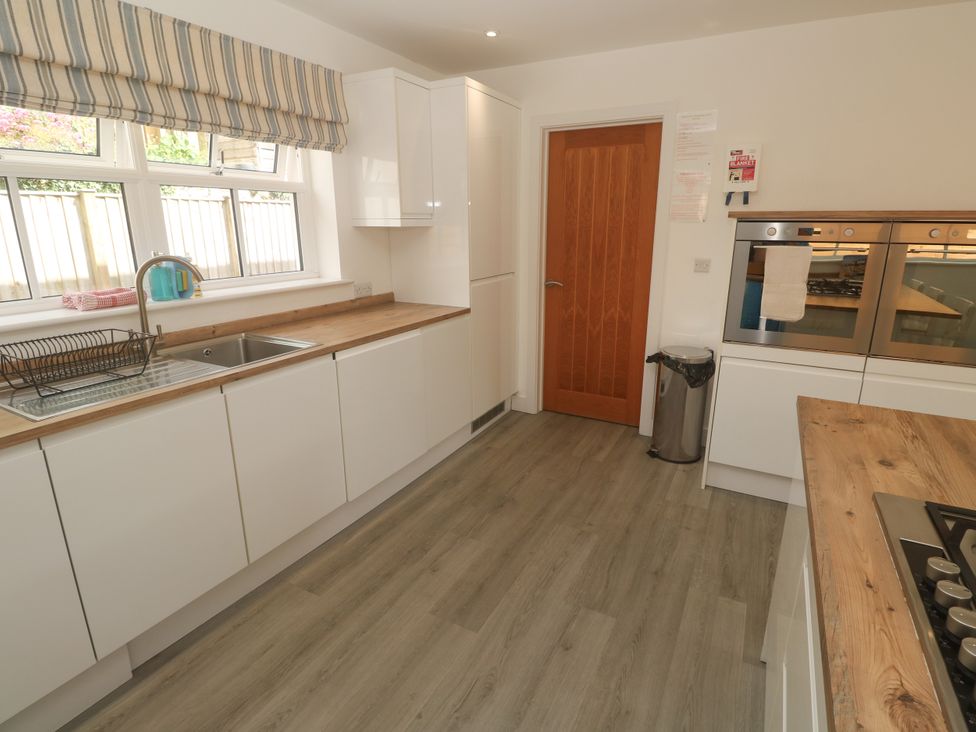 A kitchen with appliances and cabinetry at Rosevale Villa in St Ives