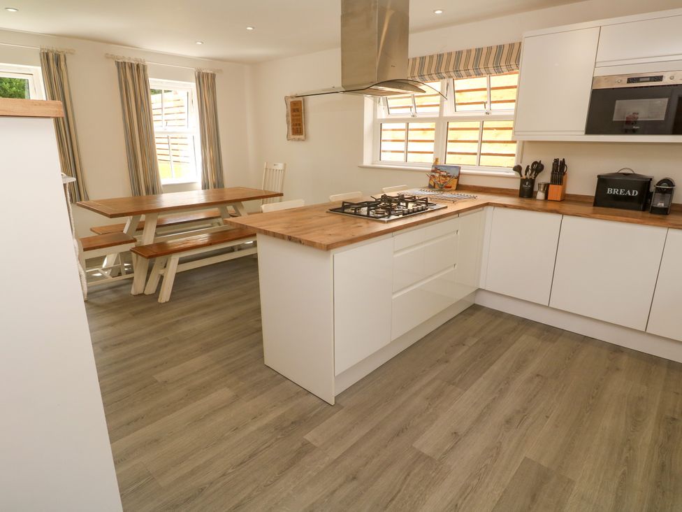A kitchen with a table and seats at Rosevale Villa St Ives