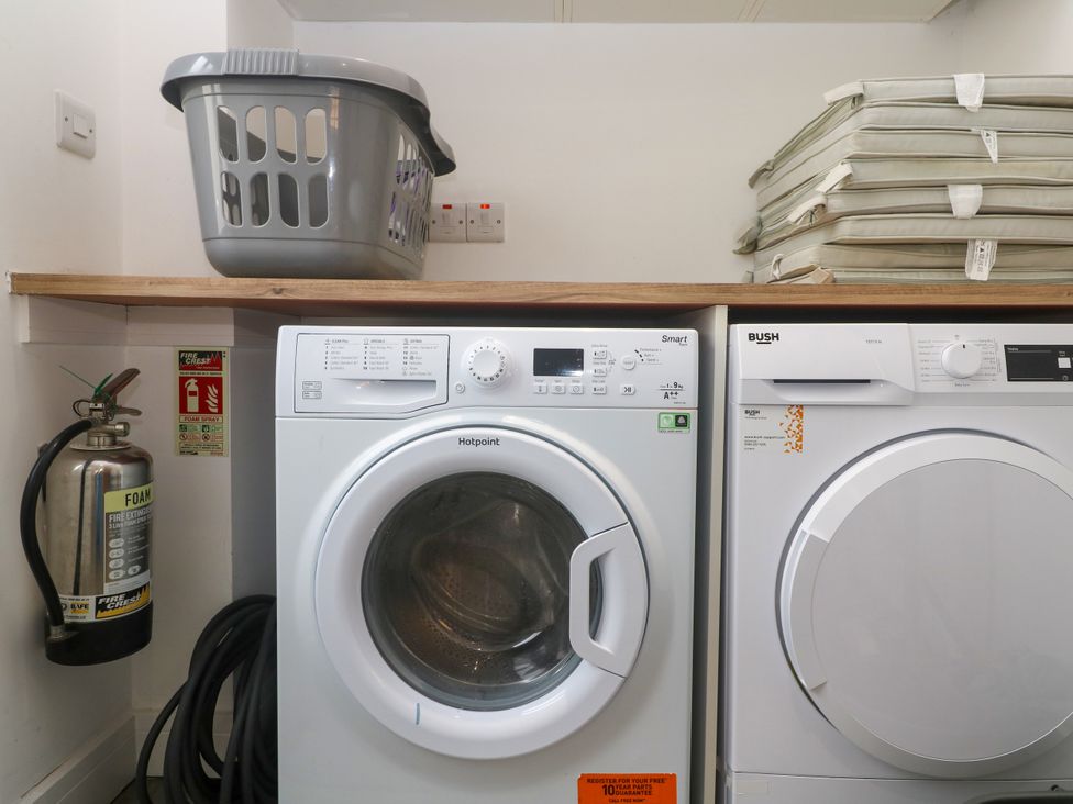 A laundry room featuring a washing machine and a tumble dryer at Rosevale Villa St Ives