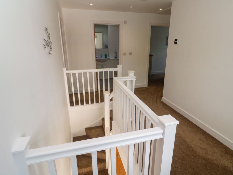 A hallway with a staircase and handrail at Rosevale Villa St Ives