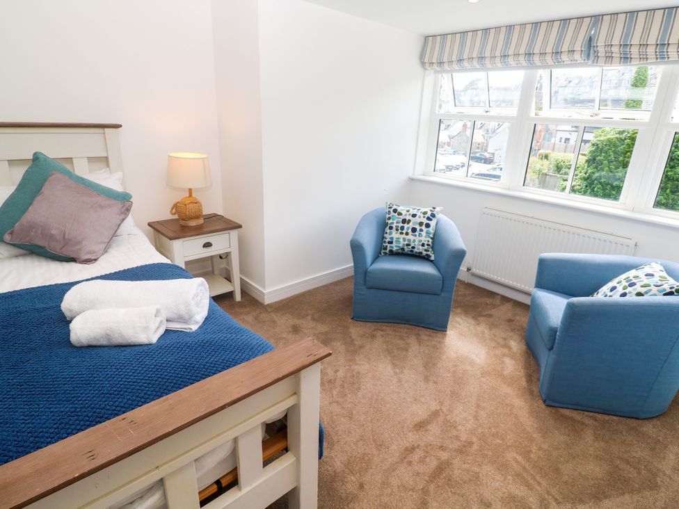 A bedroom with a bed and chairs at Rosevale Villa St Ives