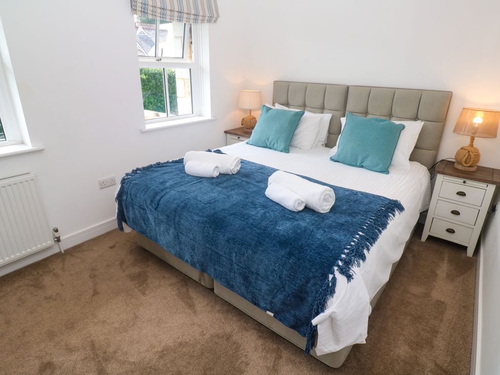 A bedroom with a bed and bedside tables at Rosevale Villa in St Ives