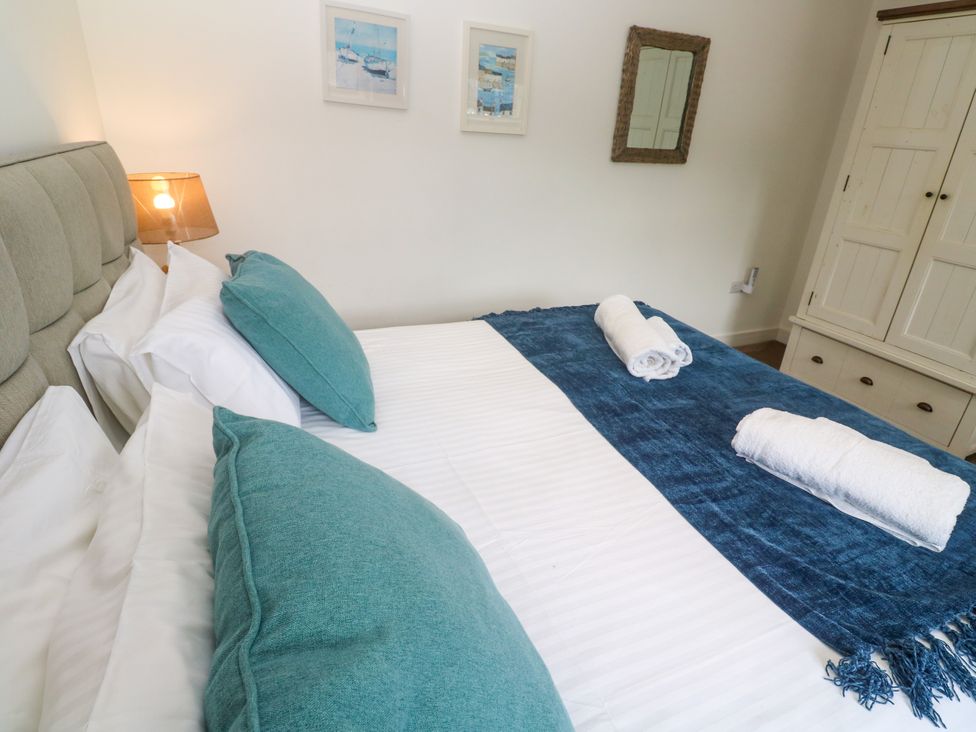 A bedroom with a bed and decorative pillows at Rosevale Villa in St Ives
