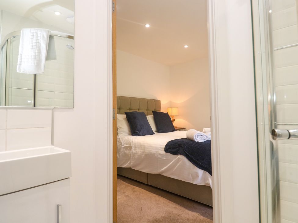 A bedroom with a bed and bathroom view at Rosevale Villa St Ives