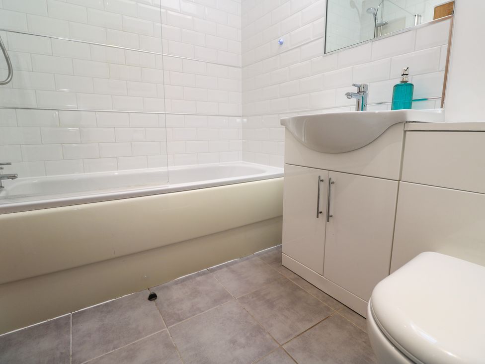 A bathroom featuring a bath tub, sink, mirror, and toilet at Rosevale Villa St Ives