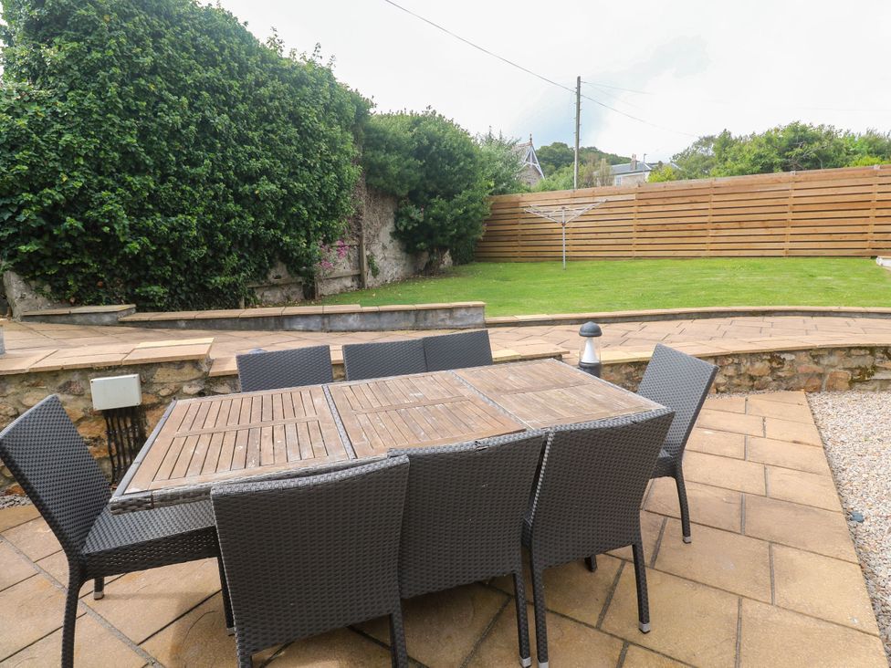 A garden with a table and chairs at Rosevale Villa in St Ives