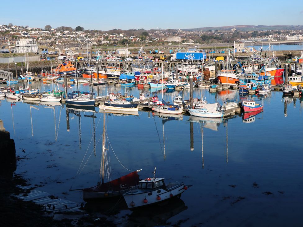 A harbor filled with boats reflected in the water at Rosevale Villa, St Ives