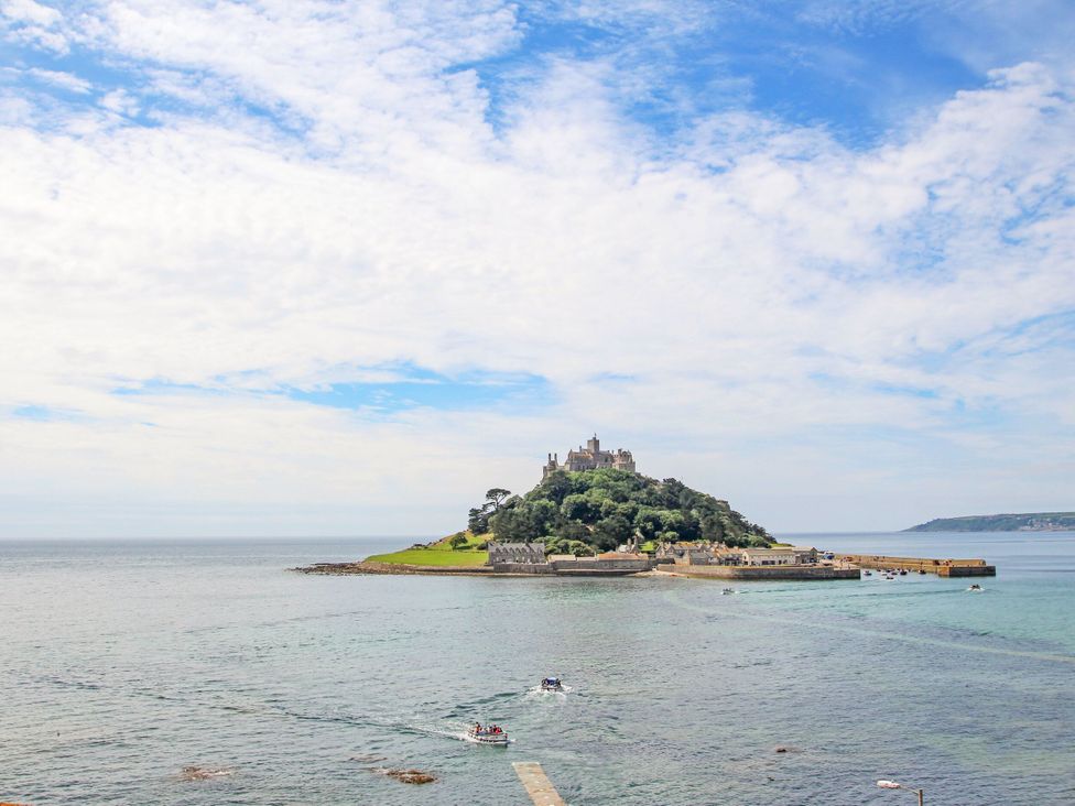 An island with a castle and boats near the shore at Rosevale Villa in St Ives