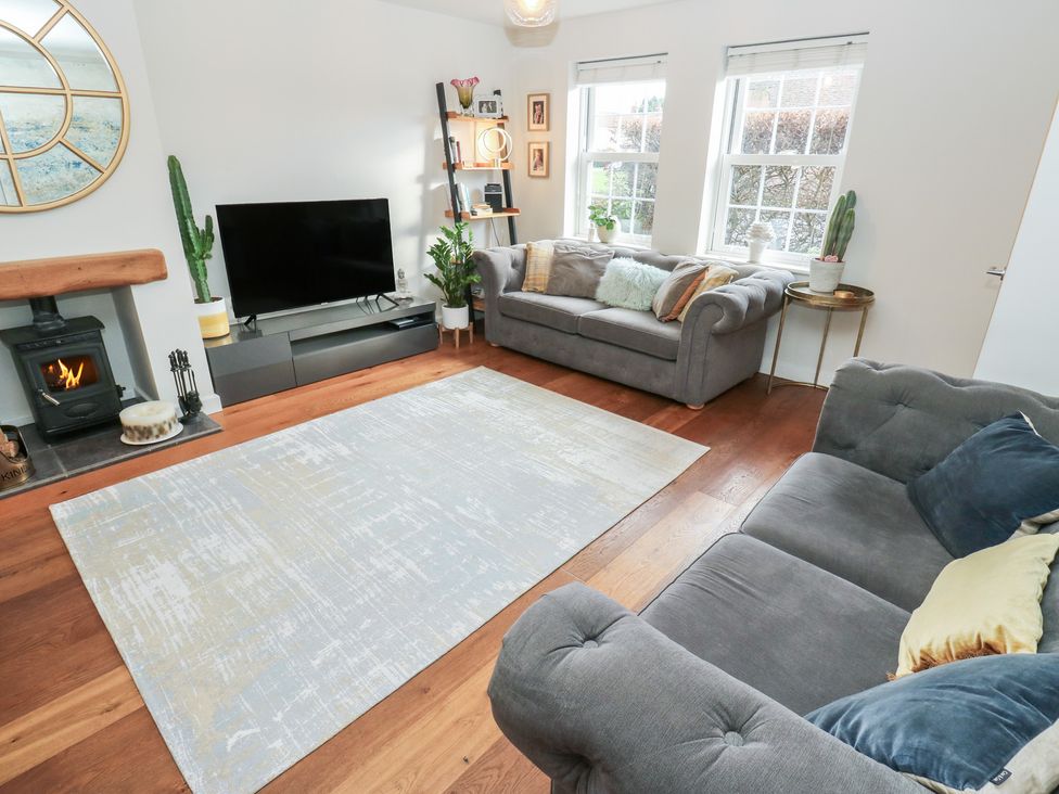 A living room with a sofa and television at Olive Tree Cottage in York