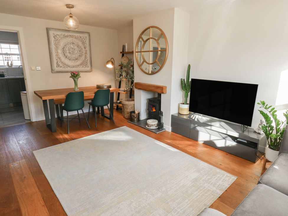 A living room with a dining table and chairs at Olive Tree Cottage in York
