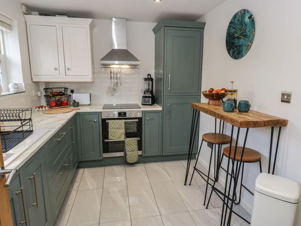 A kitchen with cabinets and appliances at Olive Tree Cottage in York