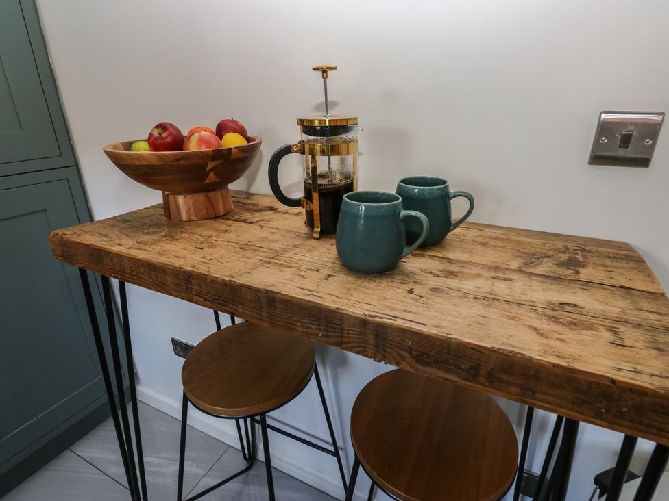 A kitchen table with fruit and mugs at Olive Tree Cottage, York
