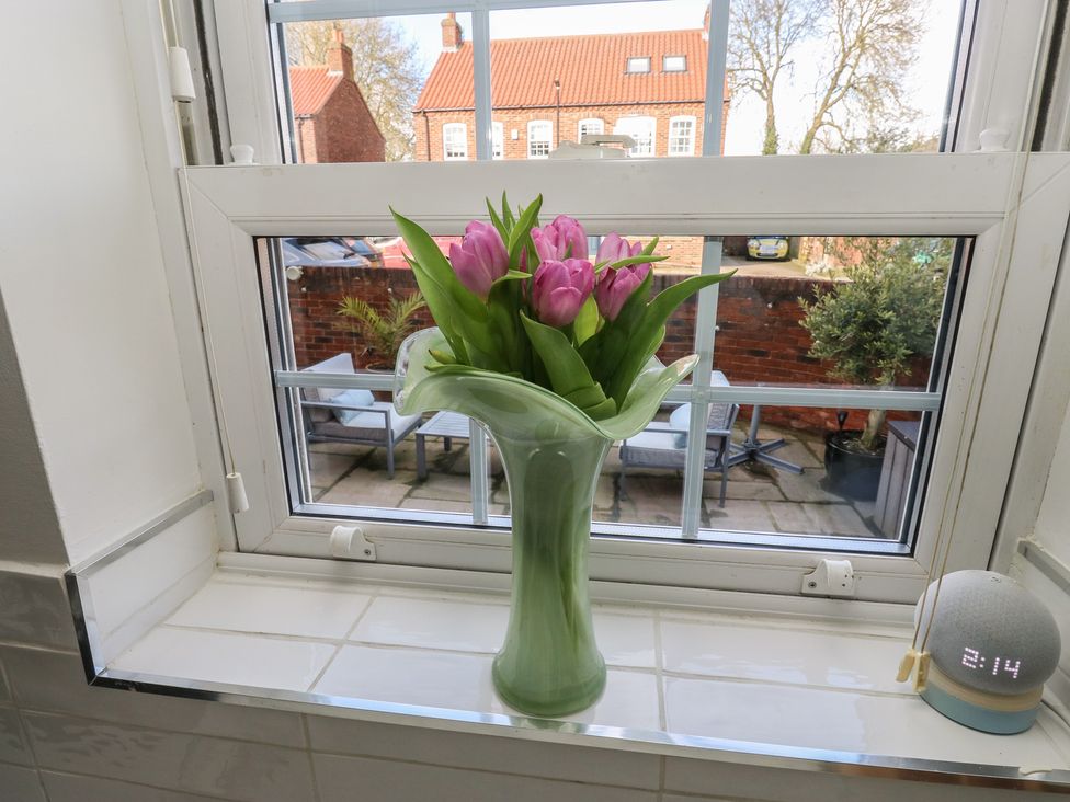 A vase with tulips on a windowsill at Olive Tree Cottage in York
