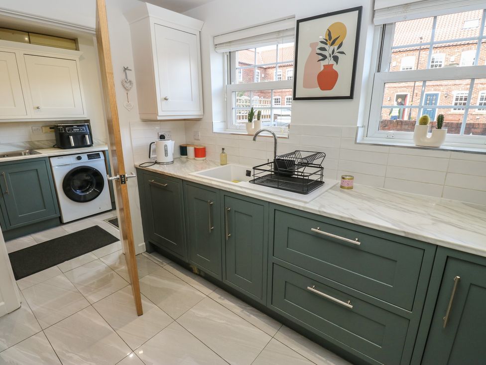 A kitchen with cabinets and a sink at Olive Tree Cottage in York