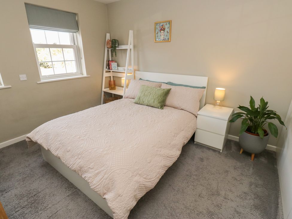 A bedroom with a bed and bedside table at Olive Tree Cottage in York