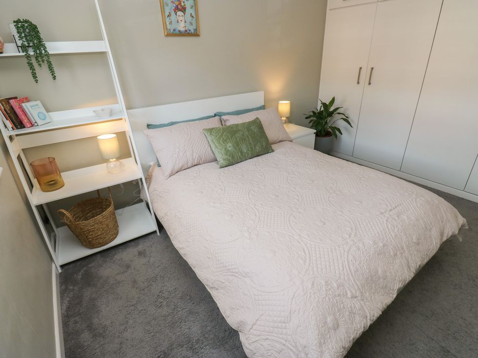 A bedroom with a bed and shelf at Olive Tree Cottage in York