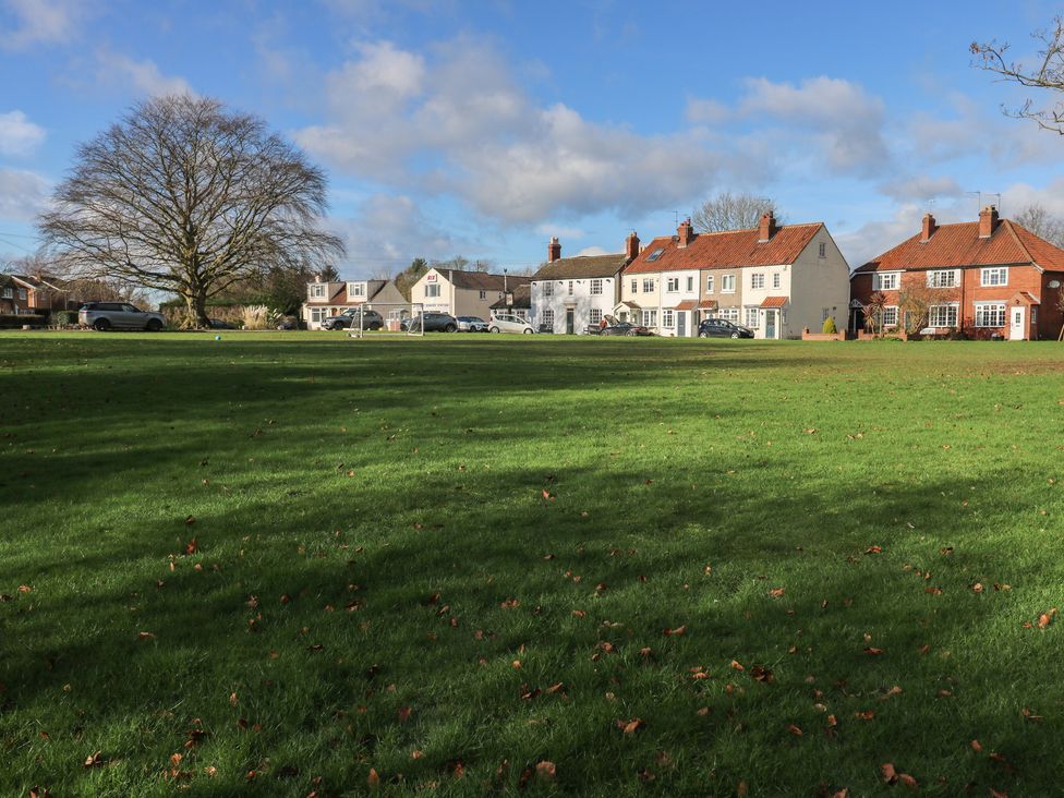 A row of houses next to a green field at Olive Tree Cottage, York