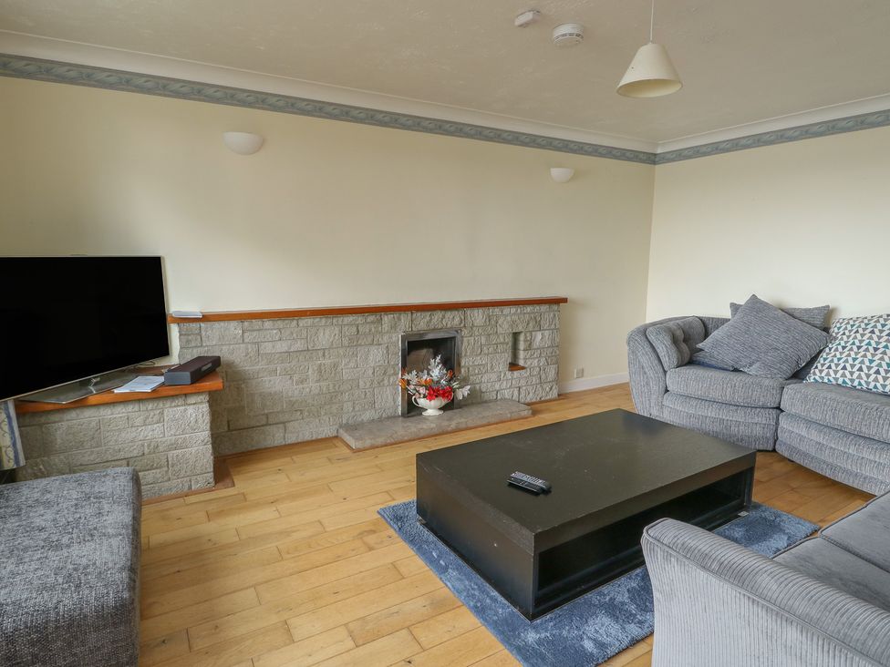 A living room with a television and fireplace at Bryn Y Felin in Y Felinheli
