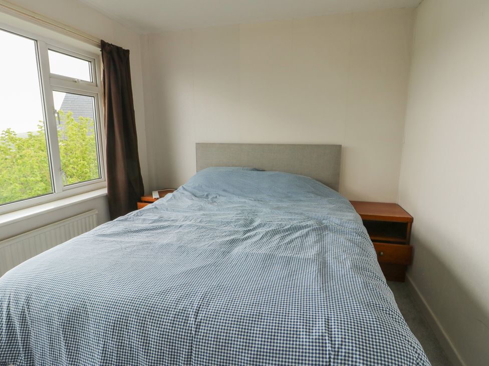A bedroom with a bed and window at Bryn Y Felin in Y Felinheli