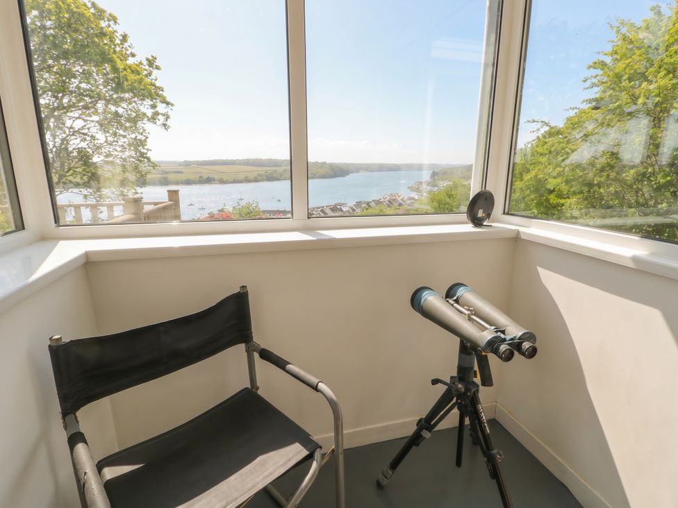 A conservatory with a telescope and chair at Bryn Y Felin in Y Felinheli