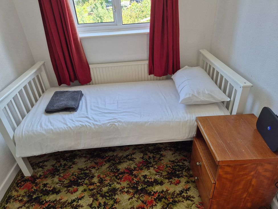 A bedroom with a single bed and bedside table at Bryn Y Felin in Y Felinheli