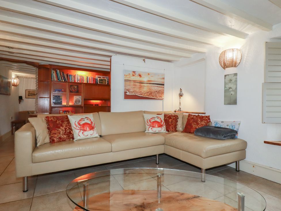 A living room with a sofa and bookshelf at Plenteth in Truro