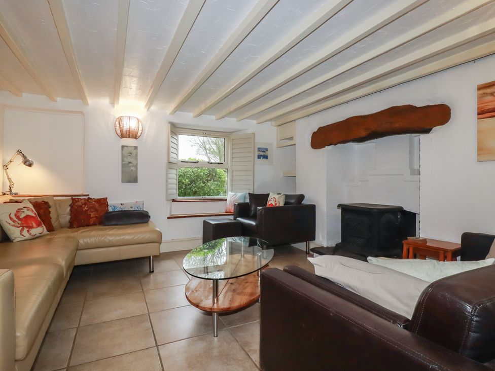 A living room with a sofa and table at Plenteth in Truro