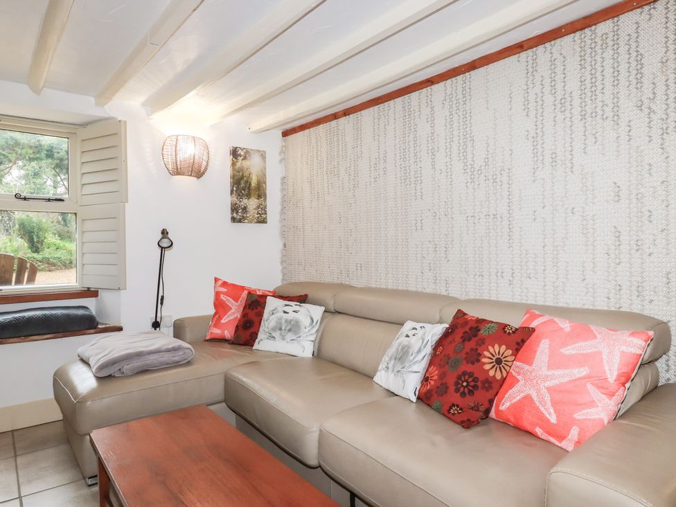 A living room with a couch, pillows, and a window at Plenteth in Truro