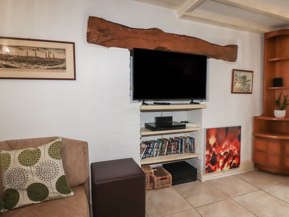 A living room with a TV and shelf at Plenteth in Truro