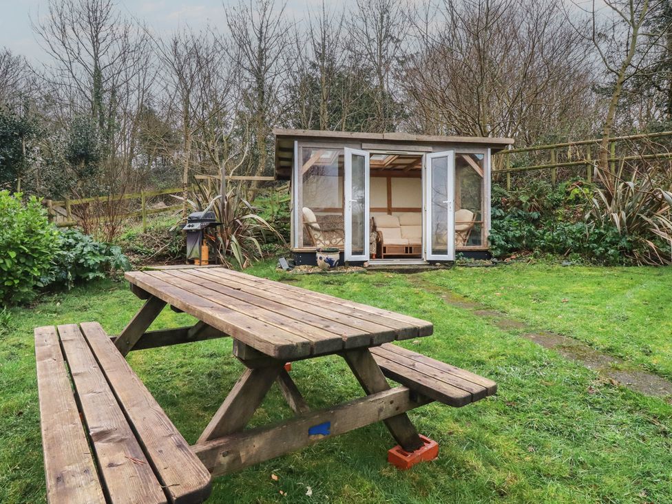 A garden with a picnic table and a shed at Plenteth, Truro
