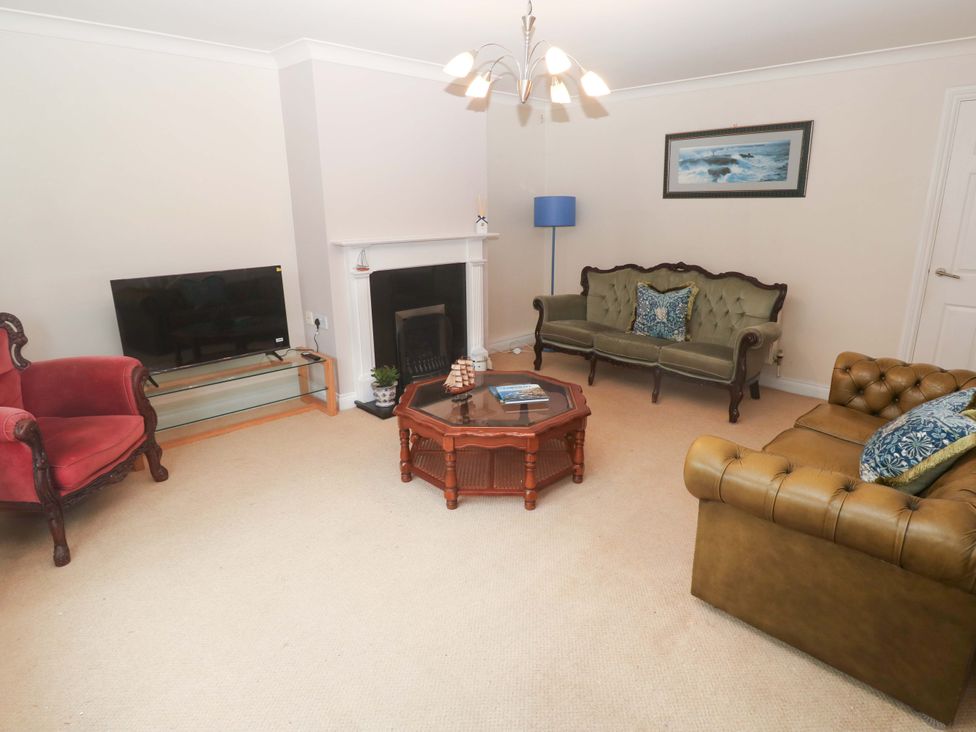 A living room with a television and three sofas at 16 Forth An Nance in Redruth