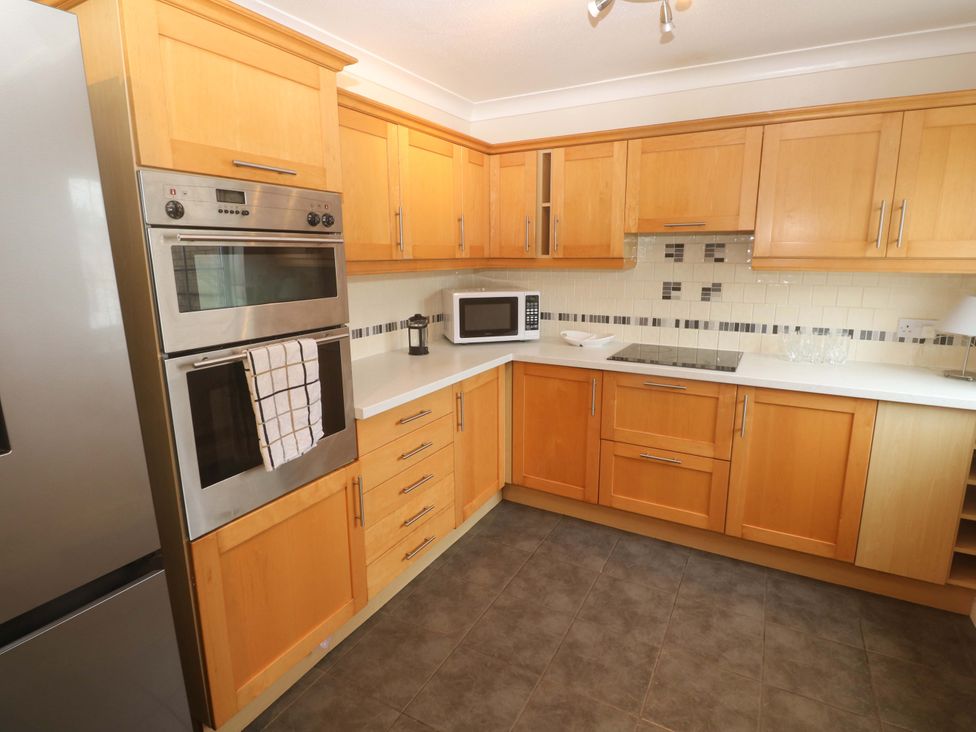 A kitchen with wooden cabinets and appliances at 16 Forth An Nance Redruth