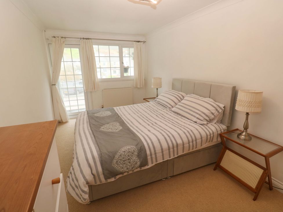 A bedroom with a bed, bedside table, lamp, and window at 16 Forth An Nance Redruth