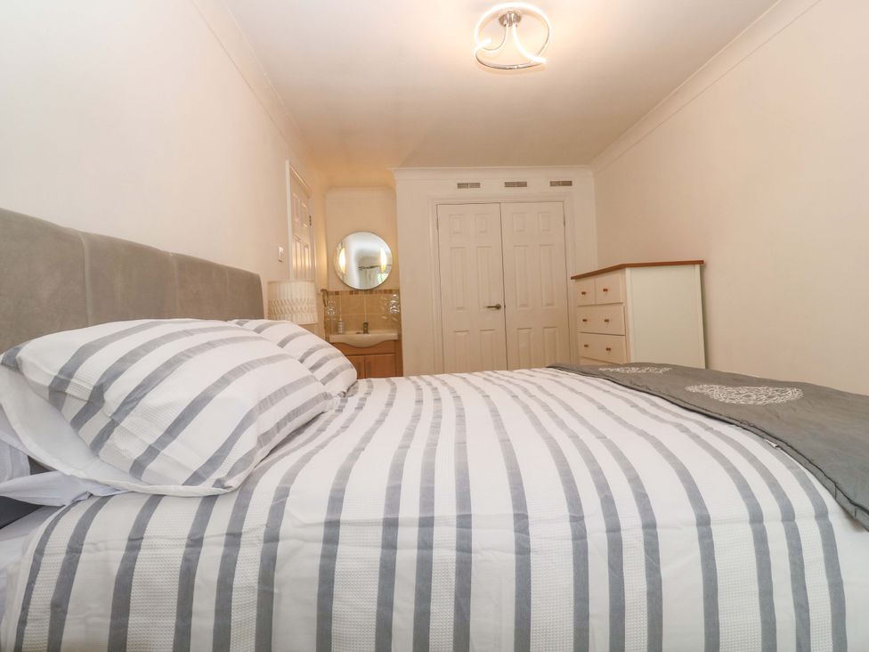 A bedroom with a bed and a mirror at 16 Forth An Nance Redruth
