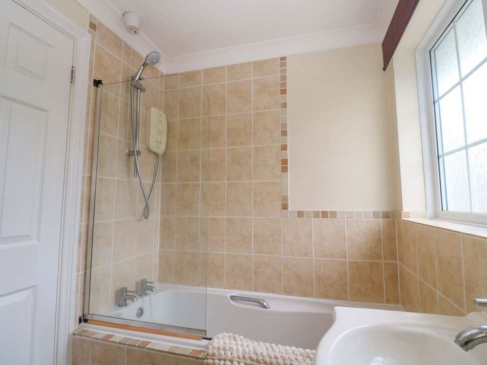A bathroom with a bath and shower at 16 Forth An Nance in Redruth
